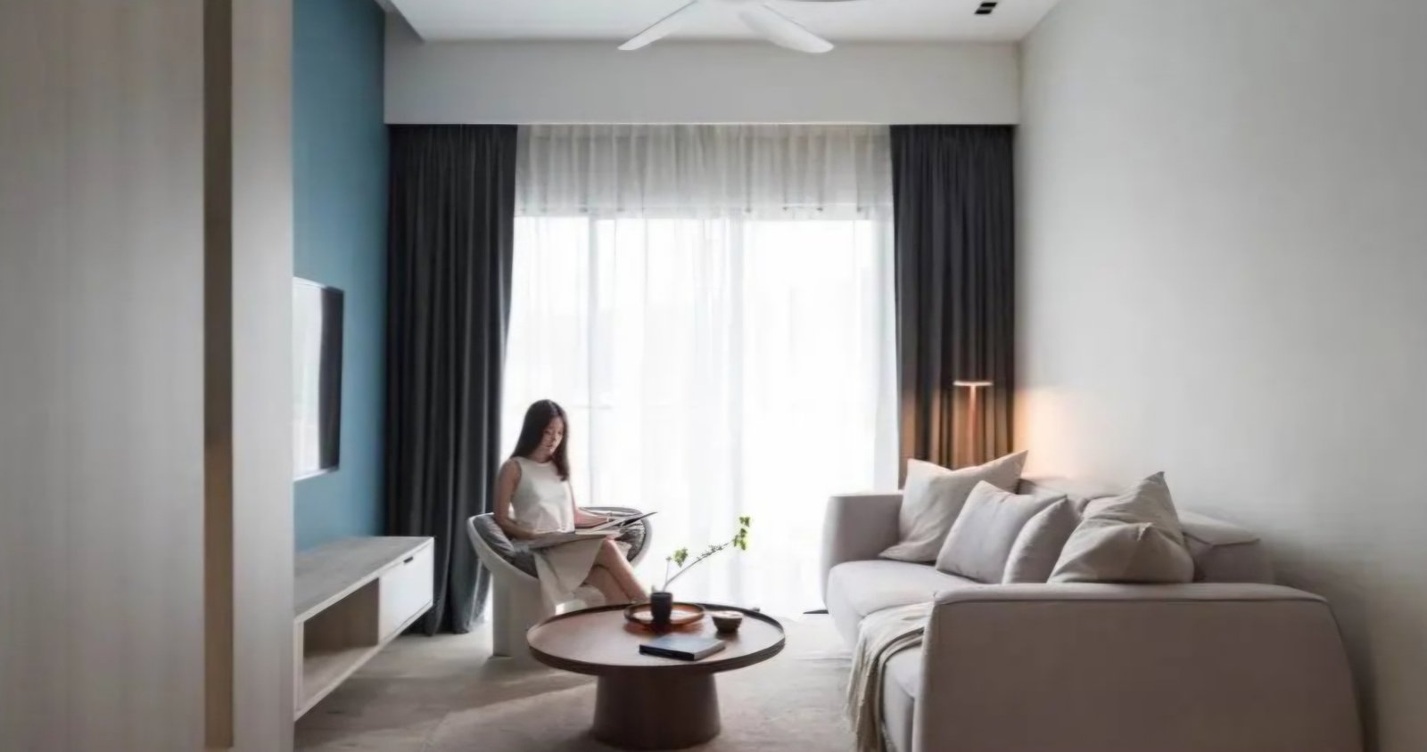 Ruang keluarga Pondok Indah Residence dengan sofa dan aksen dinding biru